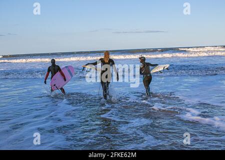 Junge einheimische Frau, die in der Nordsee bei Seaton in Hartlepool, County Durham, Großbritannien, surft Stockfoto