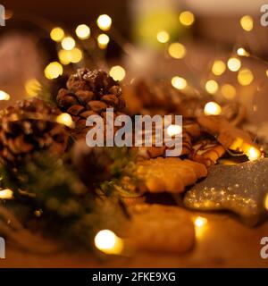 Traditionelle Plätzchen und Tannenzapfen mit goldenem Bokeh, Weihnachtskonzept und Frohes neues Jahr. Stockfoto