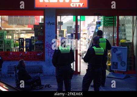 Köln, Deutschland. April 2021. Mitarbeiter der öffentlichen Ordnung überwachen die Schließung eines Supermarkts zu Beginn der Ausgangssperre um 21:00 Uhr. Quelle: Henning Kaiser/dpa/Alamy Live News Stockfoto