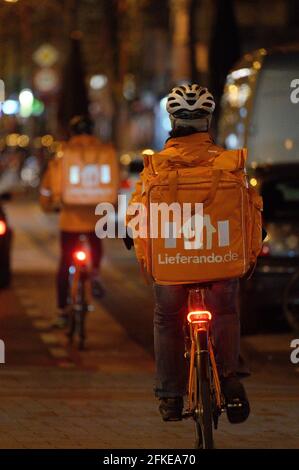 Köln, Deutschland. April 2021. Mitarbeiter des Lieferservice fahren Fahrräder, um bestellte Lebensmittel an Kunden zu liefern, nachdem die Ausgangssperre um 21:00 Uhr beginnt. Quelle: Henning Kaiser/dpa/Alamy Live News Stockfoto