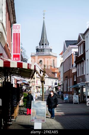 Aurich, Deutschland. April 2021. Hinter den Häusern in der Burgstraße im Stadtzentrum steht der Kirchturm der historischen Lamberti-Kirche. Quelle: Hauke-Christian Dittrich/dpa/Alamy Live News Stockfoto