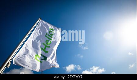 Schleswig, Deutschland. April 2021. Vor dem Helios Klinikum Schleswig flattert im Wind eine Fahne mit dem Logo der Helios Kliniken Gruppe. Quelle: Christian Charisius/dpa/Alamy Live News Stockfoto