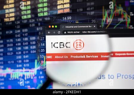 ICBC-Firmenlogo auf einer Website mit verschwommenen Börsenentwicklungen im Hintergrund, die auf einem Computerbildschirm durch eine Lupe gesehen werden Stockfoto
