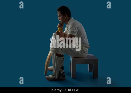 Ein Schlagmann, ein Cricketspieler, der in der Ankleidekabine sitzt Stockfoto