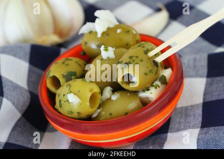 Grüne Oliven mit Feta-Käse und roten Paprika in transparent Kunststoffbox Stockfoto