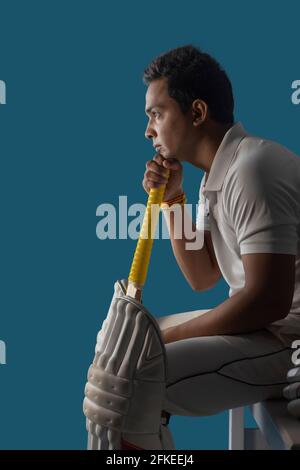 Ein Schlagmann, ein Cricketspieler, der in der Ankleidekabine sitzt Stockfoto