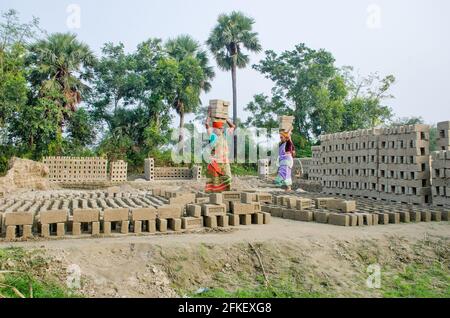 Bild eines Ziegelofens im abgelegenen Hooghly-Viertel. Erwachsene Arbeiter arbeiten hart daran, die rohen Ziegelsteine im Ofen zum Backen zu arrangieren. Stockfoto