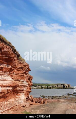 Bunter Sandstone Cliff auf Hilbre Island, mit Blick auf Middle Eye bei High Tide, The Wirral, Merseyside, Großbritannien Stockfoto