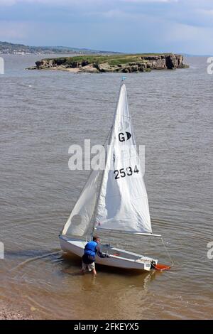 Seemann in GP14 Dingy landet auf Hilbre Island bei High Tide mit Blick über Middle Eye, Dee Estuary, Wirral, Großbritannien Stockfoto