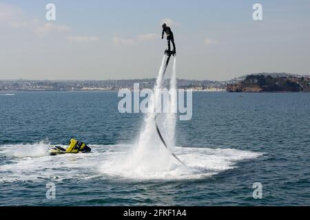 Ein Fliegerboarder in Aktion an der Strandpromenade von Torquay in Devon. Stockfoto