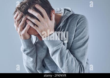Psychische Gesundheitsprobleme, verstörter depressiver Mann mit Kopf in den Händen, selektiver Fokus Stockfoto