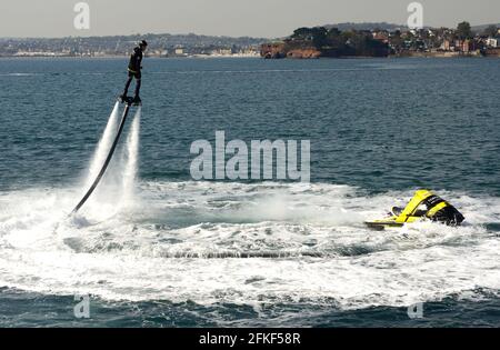 Ein Fliegerboarder in Aktion an der Strandpromenade von Torquay in Devon. Stockfoto