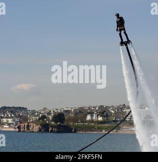 Ein Fliegerboarder in Aktion an der Strandpromenade von Torquay in Devon. Stockfoto