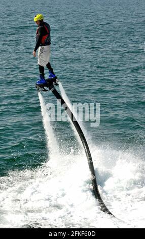 Ein Fliegerboarder in Aktion an der Strandpromenade von Torquay in Devon. Stockfoto