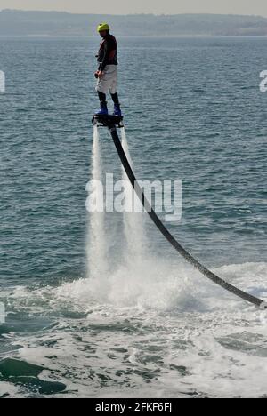 Ein Fliegerboarder in Aktion an der Strandpromenade von Torquay in Devon. Stockfoto