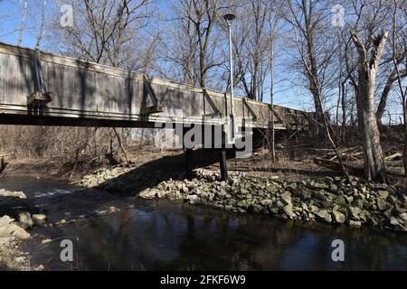Alte Holzbrücke über einen kleinen Bach im Frühjahr Stockfoto
