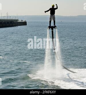 Ein Fliegerboarder in Aktion an der Strandpromenade von Torquay in Devon. Stockfoto