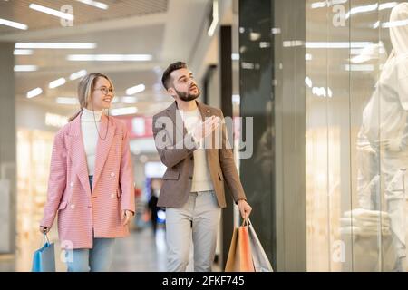 Ein Mann und eine Frau, die in einem modernen Einkaufszentrum einkaufen Stockfoto