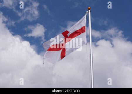 Rote und weiße Flagge von St. George England gegen den blau bewölkten Himmel. Hochwertige Fotos Stockfoto