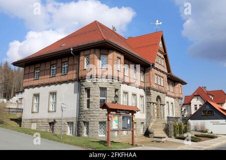 Schierke, Deutschland. April 2021. Das historische Rathaus wurde 1926 mit einer Fachwerkdecke mit aufwändigen bunten Schnitzereien erbaut. Die Schnitzereien repräsentieren die Berufe der Region, vom Schnitzer über Holzfäller bis zum Tourismusgewerbe. Es wurde 2007 umfassend renoviert. Quelle: Peter Gercke/dpa-Zentralbild/ZB/dpa/Alamy Live News Stockfoto