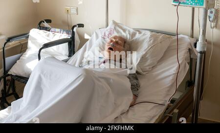 Ankara, Türkei - 2021. März: Alte Frau, die in einem Krankenhausbett schläft und Medikamente erhält, mit Sauerstoffversorgung Stockfoto