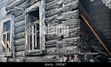 Verkohlte Ruinen. Feuer im Dorf. Das nach außen verbrannte Dorfhaus (Blockhütte) steht noch Stockfoto