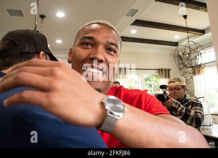 Lake Forest, USA. Mai 2021. Der deutsch-amerikanische Fußballspieler Amon-Ra St. Brown (r) umarmt einen Gast, nachdem er im NFL-Entwurf von den Detroit Lions ausgewählt wurde. Quelle: Maximilian Haupt/dpa/Alamy Live News Stockfoto