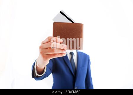 Elegant gekleideter Geschäftsmann, der eine Kreditkarte in die Tasche steckte. Mann in schwarzem Anzug, weißem Hemd und Krawatte. Leere Karte. Geschäftsmann steckt in seine Tasche Stockfoto
