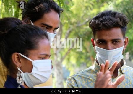 Eine Gruppe junger indischer Freunde, die medizinische Gesichtsmasken tragen, genießt es Ihre Zeit in einem Park Stockfoto