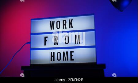 Arbeiten von zu Hause Leuchtkasten im Studio. WFH-Text im Leuchtkasten. Vertretung der Arbeit von zu Hause für ein soziales Distanzierungskonzept während einer Coronavirus-Pandemie. WFH-Chaos Stockfoto