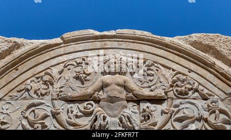 Marmorreliefs in der historischen antiken Stadt Ephesus, in Selcuk, Izmir, Türkei.Hadrianstempel und Steinbogen mit Medusa-Figur in der antiken Stadt Ephesus. Stockfoto