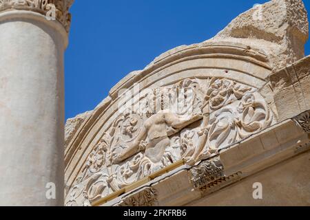 Marmorreliefs in der historischen antiken Stadt Ephesus, in Selcuk, Izmir, Türkei.Hadrianstempel und Steinbogen mit Medusa-Figur in der antiken Stadt Ephesus. Stockfoto