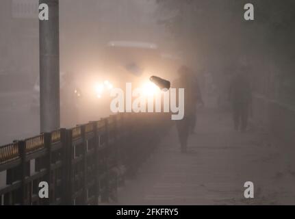 Guwahati, Assam, Indien. Mai 2021. Pendler gehen während eines Staubsturms auf einem Gehweg. Quelle: David Talukdar/ZUMA Wire/Alamy Live News Stockfoto