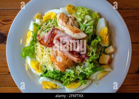 „nicht-traditioneller“ Caesar Salat (Blattgemüse, hartgekochtes Ei, Käse, goldener Bauch, Huhn, Croutons). Stockfoto