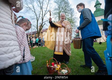 Ein ukrainischer Priester segnet Gläubige in der Nähe der griechisch-katholischen Kirche. Christen auf der ganzen Welt feiern Ostern, um die Auferstehung Jesu Christi von den Toten und das Fundament des christlichen Glaubens zu markieren. Stockfoto