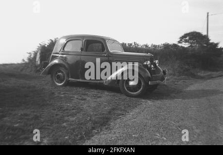 1940er Jahre, historisches Seitenprofil eines Ford-Autos der Ära mit Drahträdern, geparkt auf einem grasbewachsenen Rand oder Seitenbereich einer Landstraße, England, Großbritannien. Stockfoto