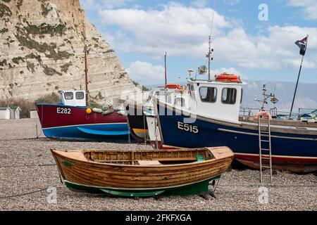 Kleine Fischerboote vertäuten am 21. April 2021 am Kiesstrand in Beer, Devon, Großbritannien Stockfoto