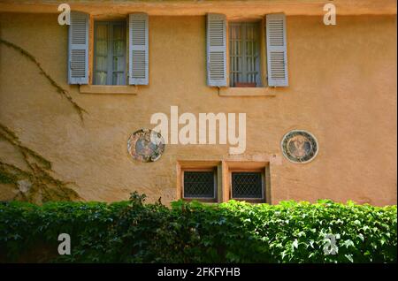 Traditionelle Hausfassade im Provençal-Stil mit ockerfarbener Stuckwand und Fenstern mit hölzernen Fensterläden in Aix-en-Provence Marseille, Frankreich. Stockfoto