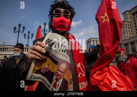 Moskau, Russland. Am 22. April 2021 liest ein kommunistischer Unterstützer die Zeitung „Prawda“ (eng: Wahrheit) auf dem Manegnaja-Platz im Zentrum Moskaus, bevor er das Mausoleum des sowjetischen Gründers Wladimir Lenin zum 151. Jahrestag seiner Geburt, Russland, besucht. Auf der Titelseite der Zeitung ist ein Porträt des kommunistischen Parteiführers Gennadi Sjuganov zu sehen. Die Prawda ist eine russische Zeitung, die früher die offizielle Zeitung der Kommunistischen Partei der Sowjetunion war, als sie mit einer Auflage von 11 Millionen Zeitungen eine der einflussreichsten im Land war Stockfoto