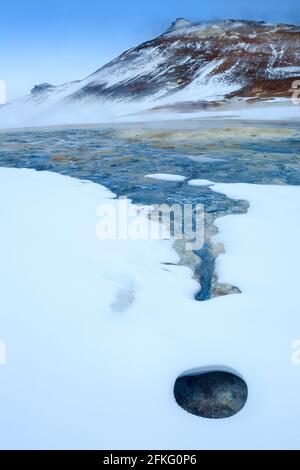 Das Hevrir-Gebiet mit kochenden Schlammtöpfen, heißen Wasserströmen und dampfenden Geysiren und bunten Felsen in Island Stockfoto