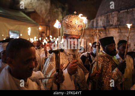 Jerusalem, Israel. Mai 2021. Äthiopisch-christlich-orthodoxe Geistliche halten Kerzen während der Zeremonie des Heiligen Feuers im äthiopischen Teil der Grabeskirche in der Altstadt Jerusalems. Östliche Gläubige glauben, dass das Heilige Feuer, das aus dem Grab Christi hervorgeht, spontan die Kraft der Auferstehung erleuchtet und repräsentiert. Quelle: Ilia Yefimovich/dpa/Alamy Live News Stockfoto