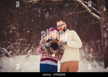 Porträt eines glücklichen Paares im Winterwald. Weihnachten und Feiertage Stockfoto