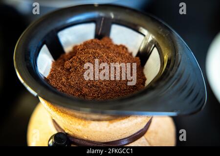Gemahlener Kaffee wird in einen Filter für die Kaffeemaschine gegeben Brühen Stockfoto