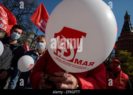 Moskau, Russland. 1. Mai 2021 Сommunists Partei Anhänger versammeln sich mit Ballons und roten Fahnen zum Tag der Arbeit, auch bekannt als 1. Mai in der Nähe des Roten Platzes in Moskau, Russland, die Inschrift auf dem Ball lautet "der 1. Mai. Der Internationale Tag Der Solidarität Der Arbeitnehmer“ Stockfoto