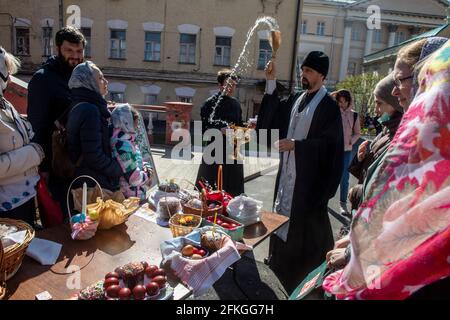 Moskau, Russland. 1. Mai 2021 ein orthodoxer Priester segnet am Vorabend des orthodoxen Osterfestes im Kloster Wysokopetrowski in Moskau, Russland, Kuchen und Eier. Es ist das männliche Stauropegionenkloster der russisch-orthodoxen Kirche in Moskau; im Stadtzentrum an den Abfahrten zum Kreml auf der Petrovka-Straße gelegen Stockfoto