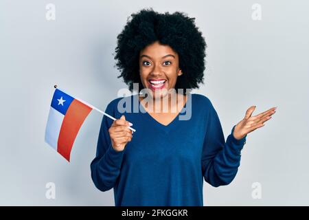 Junge afroamerikanische Frau mit chilenischer Flagge feiert Erfolge mit Glückliches Lächeln und Ausdruck des Gewinners mit erhobener Hand Stockfoto