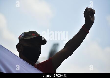 San Salvador, El Salvador. Mai 2021. Ein Protestler mit Gesichtsmaske hält während der Demonstration seine Faust hoch.während der COVID-19-Pandemie gingen die Arbeiter am Internationalen Arbeitertag auf die Straße. (Foto von Camilo Freedman/SOPA Images/Sipa USA) Quelle: SIPA USA/Alamy Live News Stockfoto