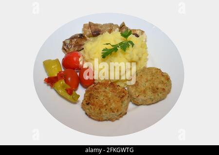 Hühnerschnitzel mit Kartoffelpüree, Tomaten, Pepperoni Stockfoto