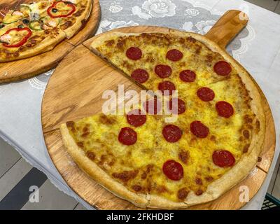 Pepperoni Pizza mit Salami auf Holztablett ohne Scheibe Stockfoto