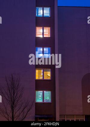 Verschiedene Lichtfarben in den Fenstern des Gebäudes Am frühen Abend Stockfoto